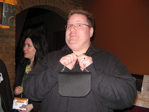 Kevin smiling and holding a tiny handbag