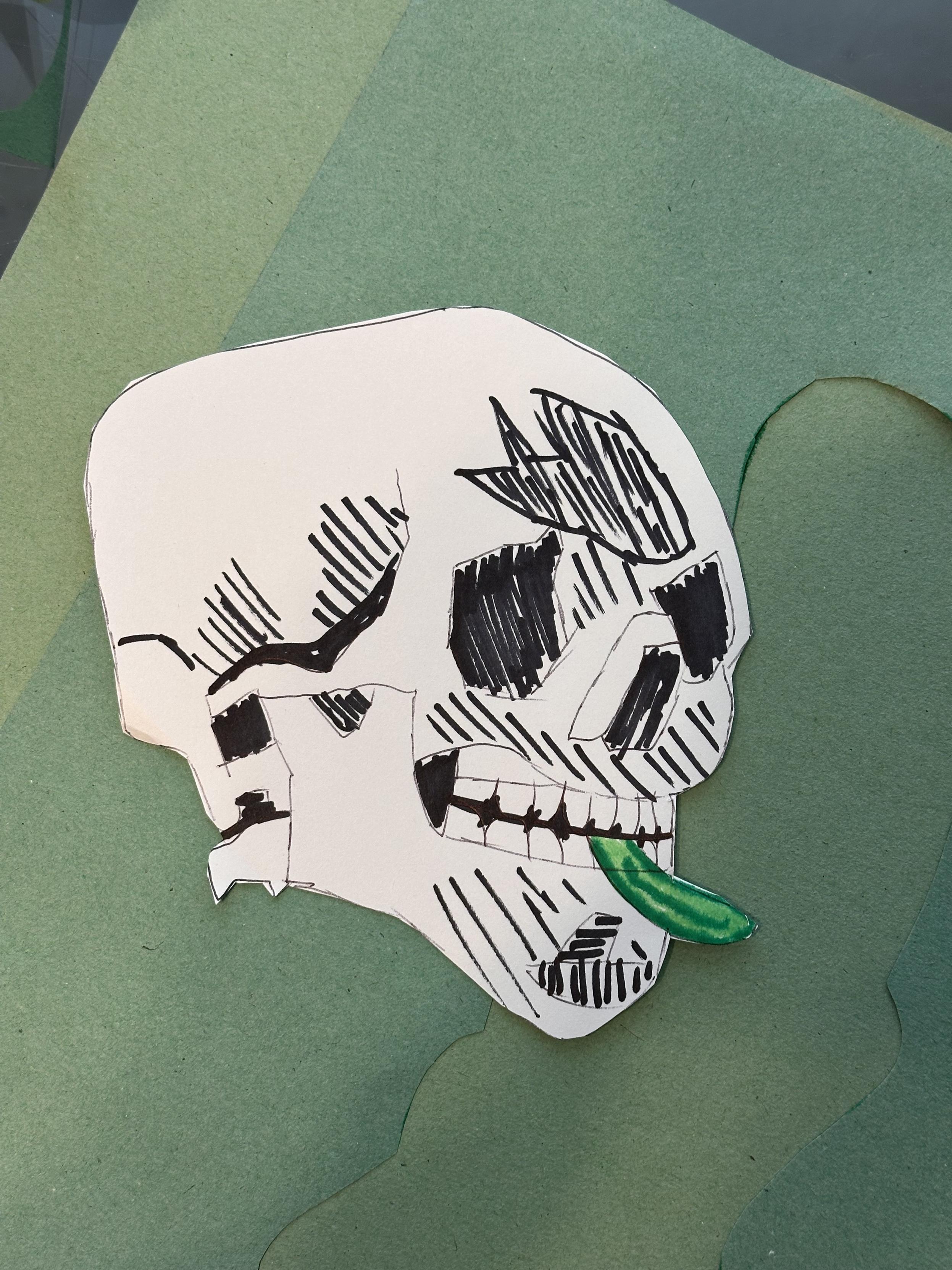 A drawing of a skull holding a pickle in its mouth. 