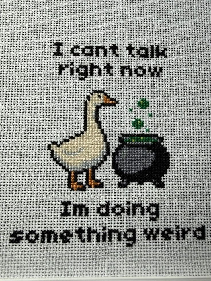 Cross stitch of a goose and a cauldron, with the text i cant talk right now I’m doing something weird
